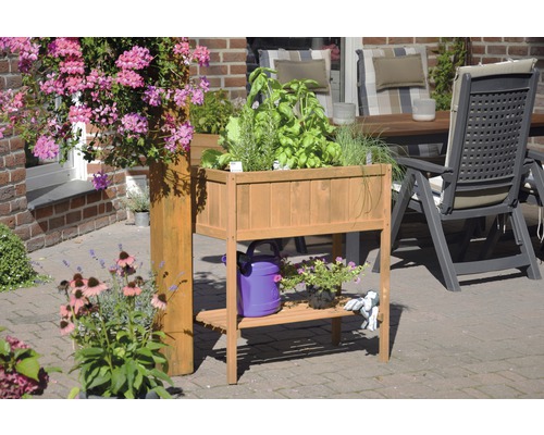 Hochbeet aus Holz mit Kräutern und Blumen auf einer Terrasse