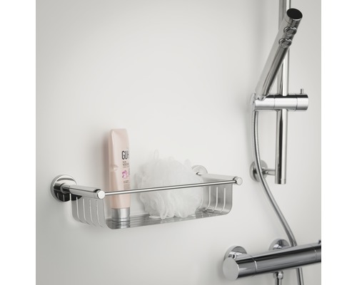 Duschablage aus Metall mit Duschgel und Badeschwamm an der Wand montiert.