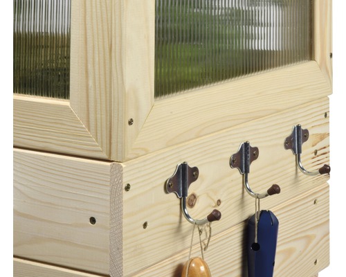 Detailansicht eines Gewächshauses aus Holz mit Haken zur Aufbewahrung von Gartengeräten