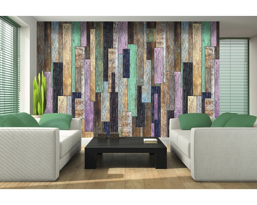 Wohnzimmer mit weißen Sofas, schwarzem Tisch und einer Wandtapete in Holzoptik.