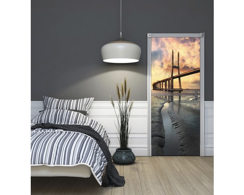Schlafzimmer mit Bett und Türposter mit Brückenmotiv