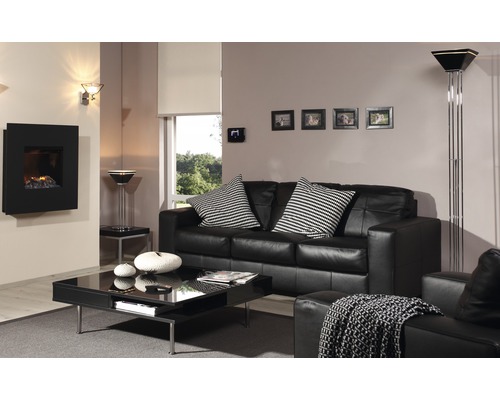 Wohnzimmer mit schwarzem Sofa, Couchtisch und elektrischem Kamin