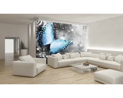 Wohnzimmer mit Fototapete mit Schmetterlingsmotiv, heller Einrichtung und Holzboden.