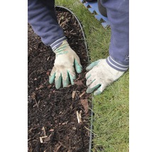 Hände mit Gartenhandschuhen arbeiten an einer Beeteinfassung zwischen Erde und Rasen.