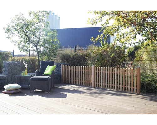 Terrasse mit Holzdeck, Lounge-Sessel und Palisadenzaun