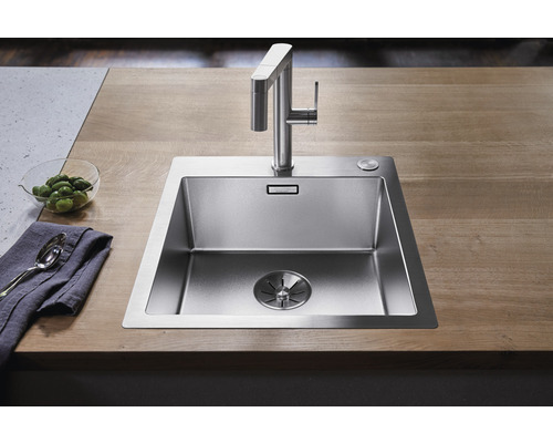 Spüle aus Edelstahl mit Wasserhahn auf einer Arbeitsplatte
