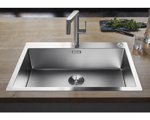 Spüle aus Edelstahl mit Wasserhahn auf einer Holzoberfläche