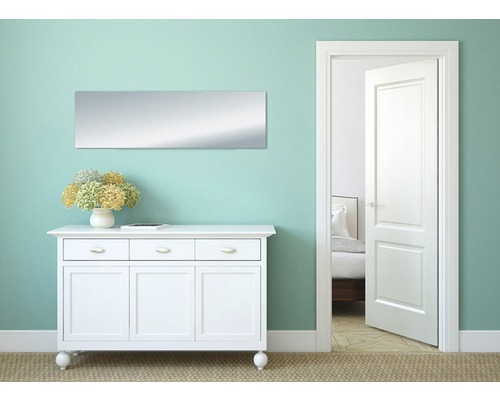 Heller Raum mit Kommode, Spiegel und offener Tür