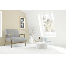 Helles Wohnzimmer mit Sessel, Tisch und Dekorationsgegenständen.