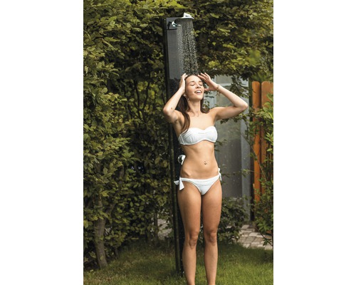 Frau unter Gartendusche im Außenbereich