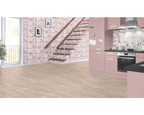 Heller Raum mit Laminatboden, Treppe, gemusterter Tapete und rosa Küche