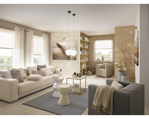 Wohnzimmer mit Sofa, Sesseln, Bücherregal und Fensterdekoration