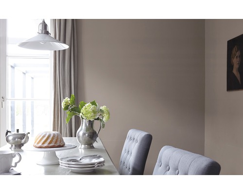 Esstisch-Szene mit Geschirr, Kuchen, Blumenvase und Pendelleuchte.