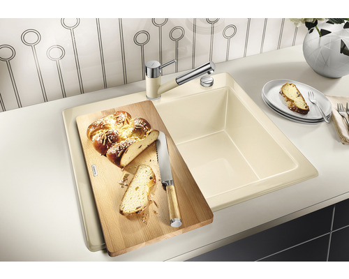 Küchenspüle mit Schneidebrett, Armatur und Hefezopf auf einer Arbeitsplatte
