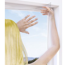 Person befestigt ein Insektenschutzgitter an einem Fenster