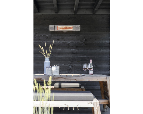 Terrasse mit Heizstrahler, Holztisch, Bänken und Dekoration