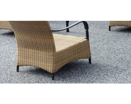 Detailansicht eines Korbsessels auf einem Untergrund mit Steinchen