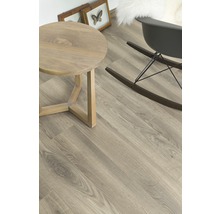 Heller Raum mit Holzboden, rundem Tisch und Schaukelstuhl