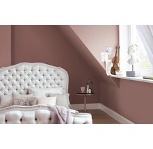 Schlafzimmer mit Bett, Nachttisch und Dekoration an der Wand