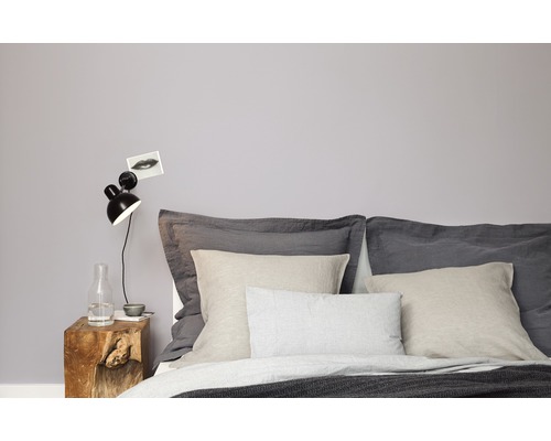 Schlafzimmer mit Bett, Kissen, Nachttisch aus Holz und Lampe