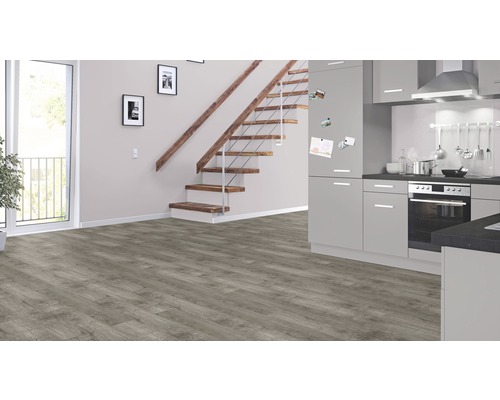 Heller Raum mit Vinylboden, Treppe und Einbauküche.