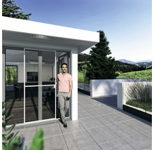 Mann betritt ein Haus mit Schiebetür und Terrasse mit Fliesenboden.