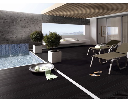 Terrasse mit Pool, Fliesenwand, Liegestühlen und Pflanzenkübeln