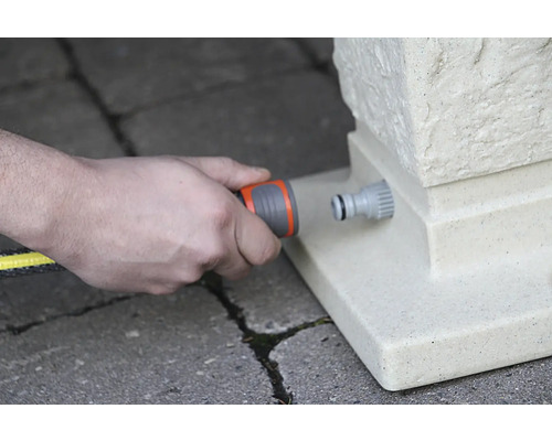 Gartenschlauch wird an einen Wasseranschluss angeschlossen