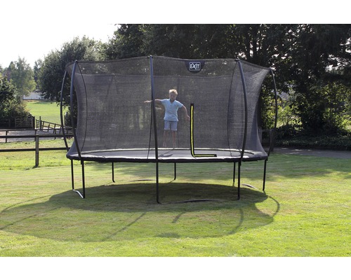 Trampolin mit Sicherheitsnetz und springendem Kind im Garten