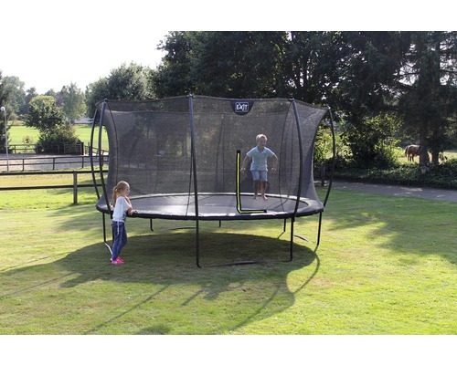 Outdoor-Trampolin mit Sicherheitsnetz im Garten mit spielenden Kindern