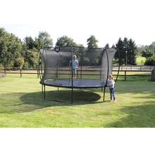 Kind auf Gartentrampolin mit Sicherheitsnetz im Garten