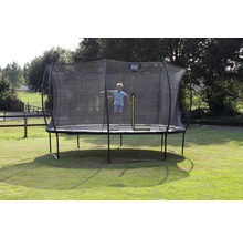Ein Junge springt auf einem runden Gartentrampolin mit Sicherheitsnetz der Marke Exit.