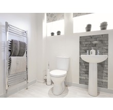 Helles Badezimmer mit Toilette, Waschtisch, Heizkörper und Handtüchern.