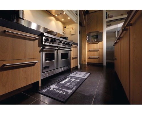 Küchenszene mit Edelstahlherd, Küchenschränken und Küchenteppich