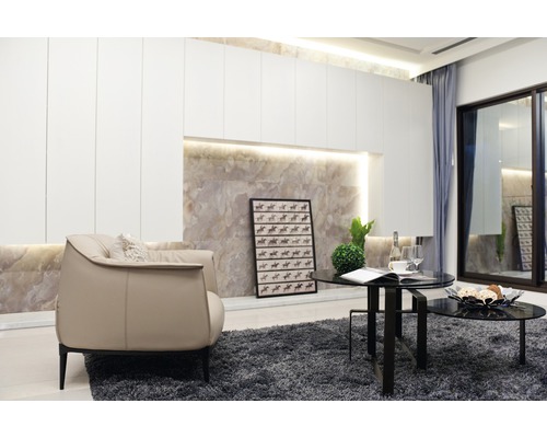 Wohnzimmer mit Sessel, Couchtisch und Dekoration auf einem grauen Teppich