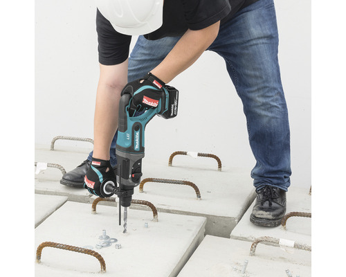 Ein Mann bohrt mit einem Akku-Bohrhammer in Betonplatten.