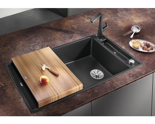 Spüle aus Granit mit Schneidebrett aus Holz, Armatur und Küchenutensilien auf Arbeitsplatte