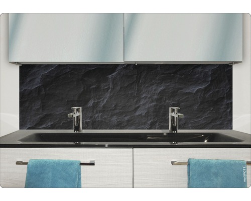 Modernes Badezimmer mit schwarzer Steinrückwand, Waschbecken und Handtüchern