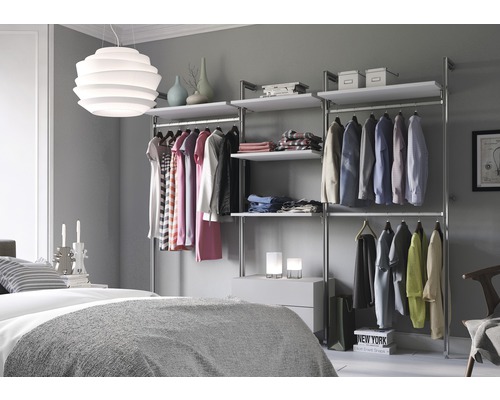 Schlafzimmer mit begehbarem Kleiderschrank aus Metall und Holzböden sowie Kleidung auf Kleiderbügeln