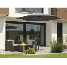 Sitzgruppe mit Sonnenschirm auf einer Terrasse vor einem Haus