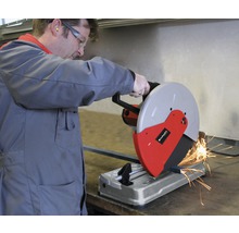 Ein Mann bedient eine Metallsäge beim Schneiden eines Metallstücks. Funken fliegen.