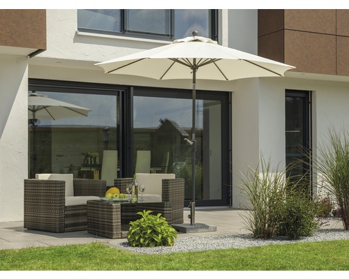 Terrasse mit Gartenmöbeln, Sonnenschirm und Bepflanzung vor einem Wohnhaus