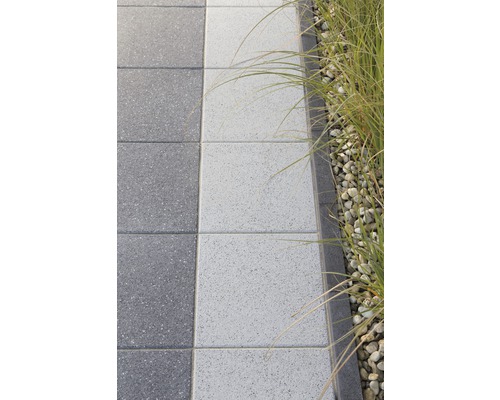 Pflastersteine auf einem Gartenweg mit Steinen und Pflanzen