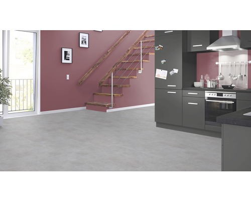 Heller Raum mit grauer Küchenzeile, Holztreppe und grossem Fenster.