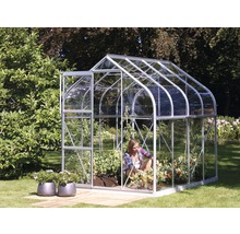 Gewächshaus mit Pflanzen und einer Person im Garten