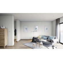 Heller Wohnraum mit Sofa, Teppich, Holzkommode und Wandbildern.