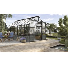 Gewächshaus mit Pflanzen und Gartenmöbeln auf einer Terrasse