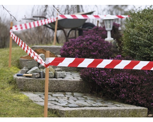 Abgesperrter Gartenbereich mit rot-weißer Warnband-Absperrung und Pflastersteintreppe