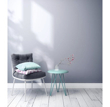 Helles Zimmer mit Stuhl, Kissen und Beistelltisch