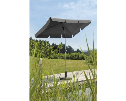Quadratischer Gartenschirm auf einer Terrasse mit Grünflächen im Hintergrund.